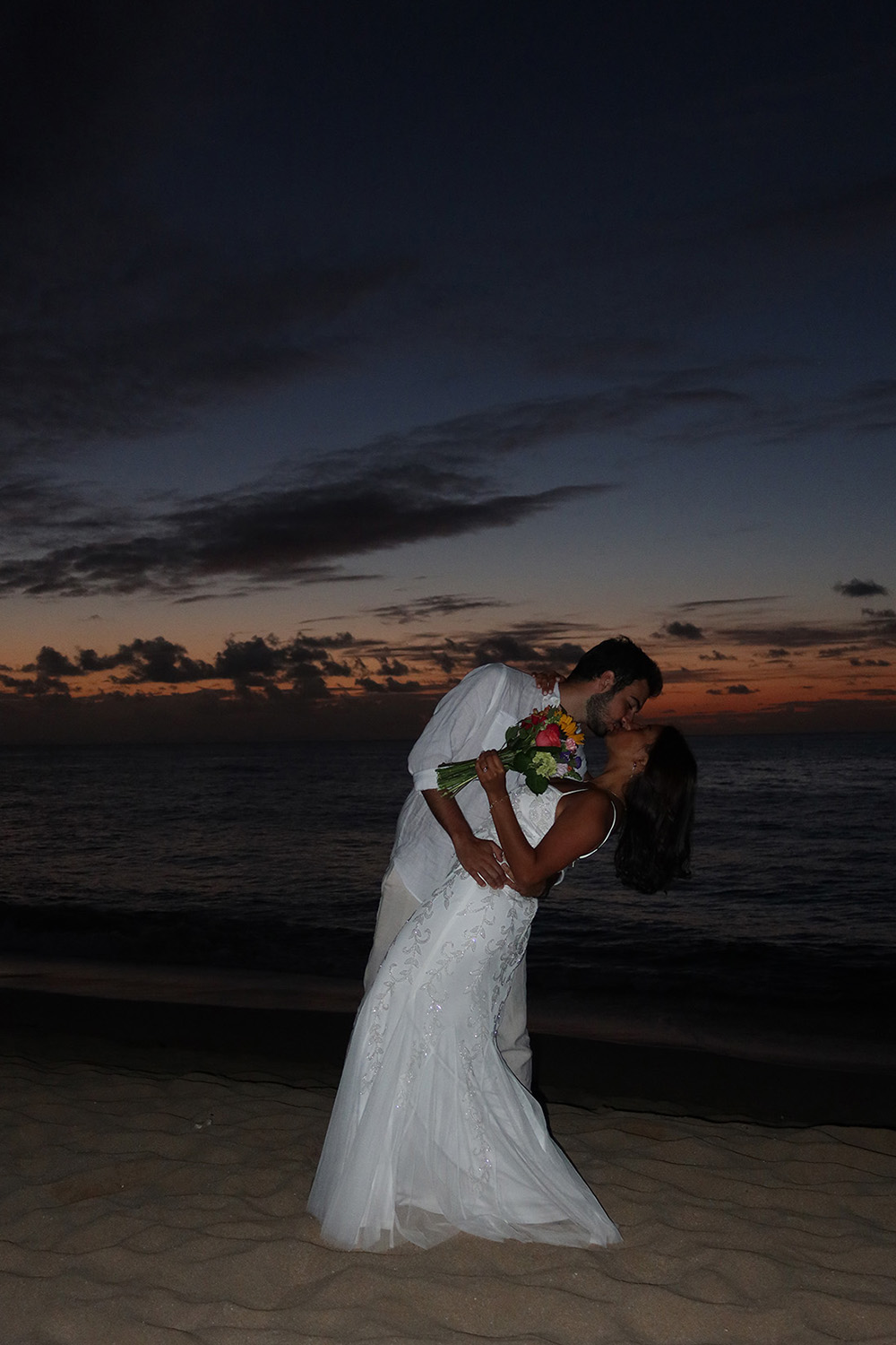 Newlyweds Kissing on Beach During Sunset